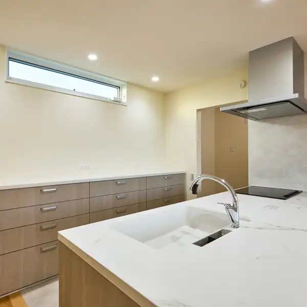 「大瀬の家」のキッチンと食器棚・高いところにあることによりカウンター式の食器棚上に目いっぱいおけて明るさや通風も確保できます。