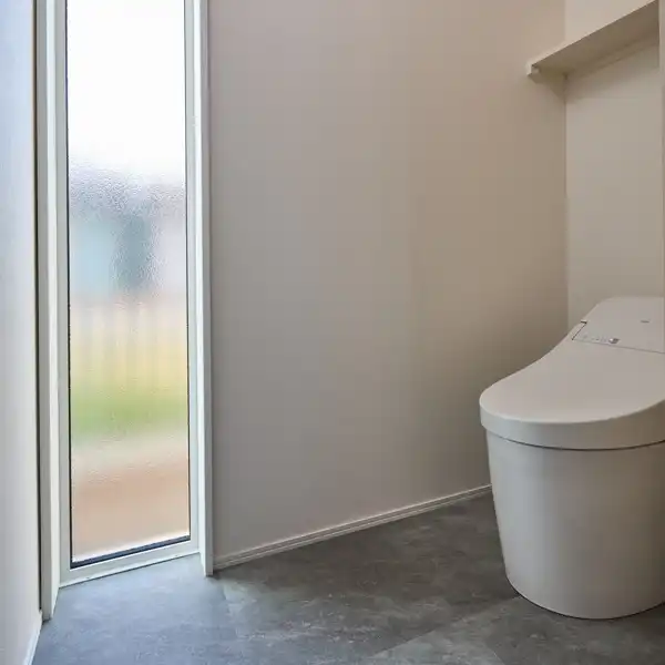 「大瀬の家」のトイレ。床から天井までの窓が特徴。ガラスは型板ガラスにし、外側には目隠しがあるため外から見えない工夫をしています。