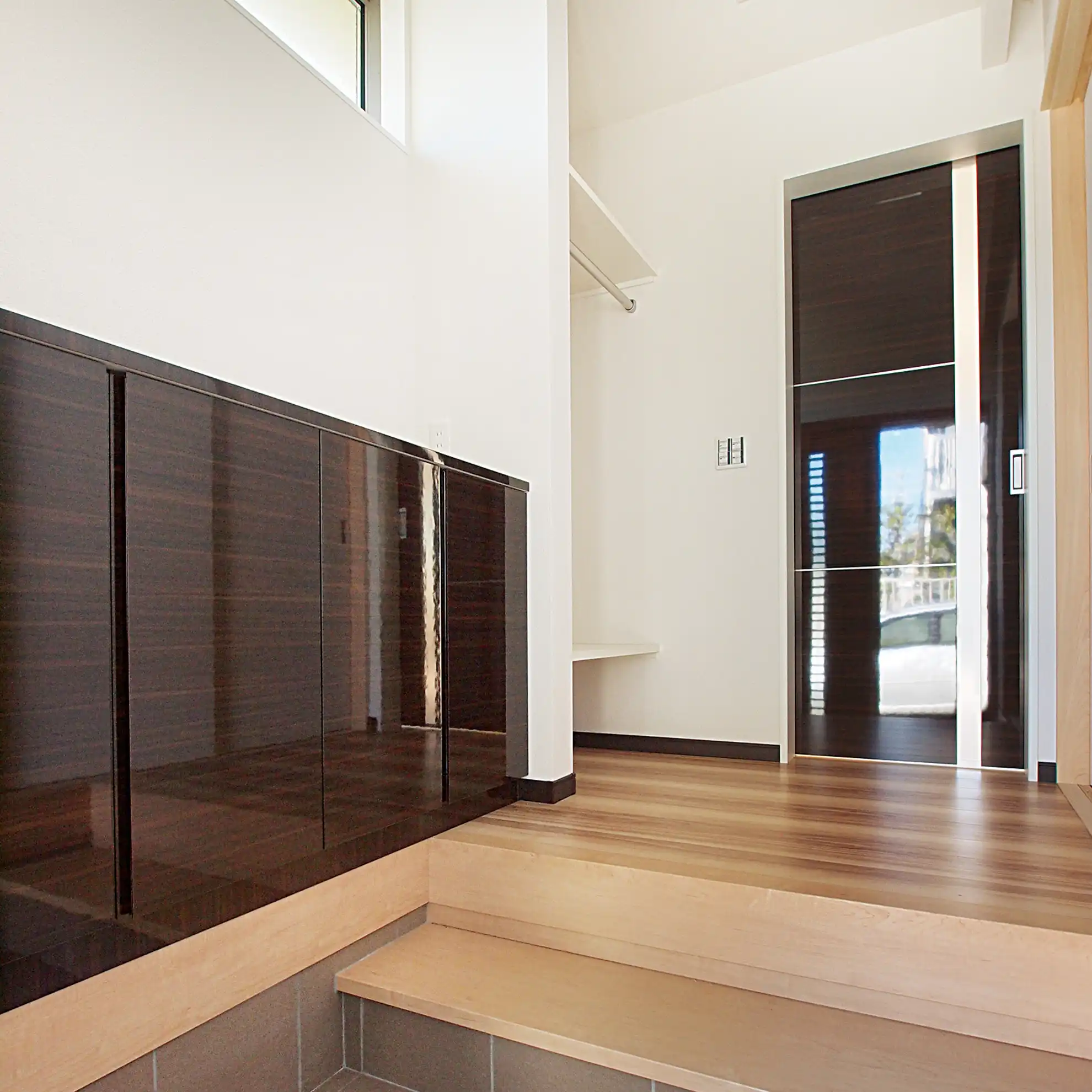 静岡県浜松市中央区富塚町の家。玄関に下駄箱だけでなくコート掛けやカバン置き場を併設することで帰宅から外出までが流れるように整うように工夫