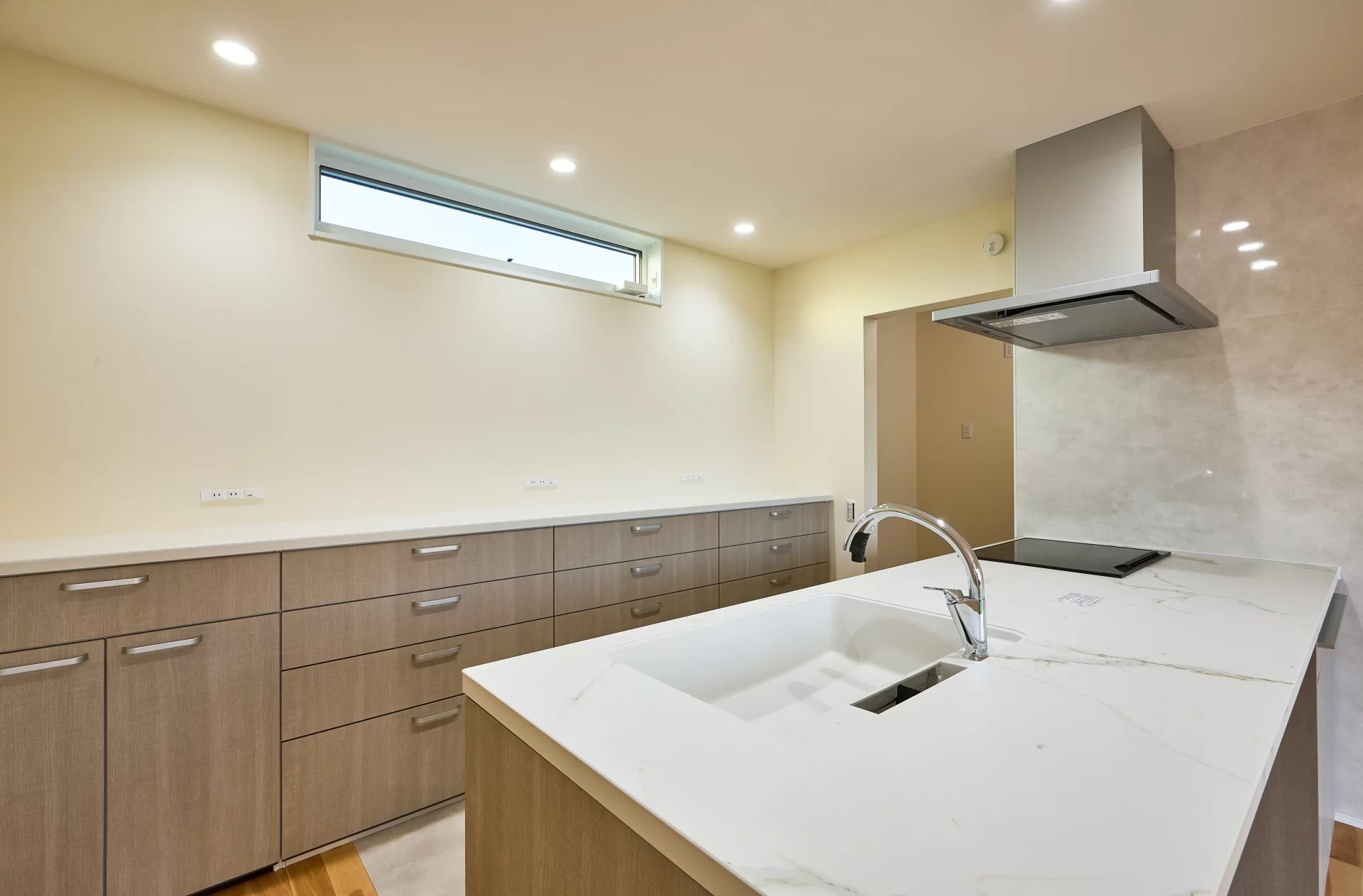 キッチンとカップボード。冷蔵庫は奥の食品庫内に冷凍庫とセットで仕舞っています。キッチンに立ったとき背面のカップボードの距離も実際に立って自分たちの最適解で決めました。