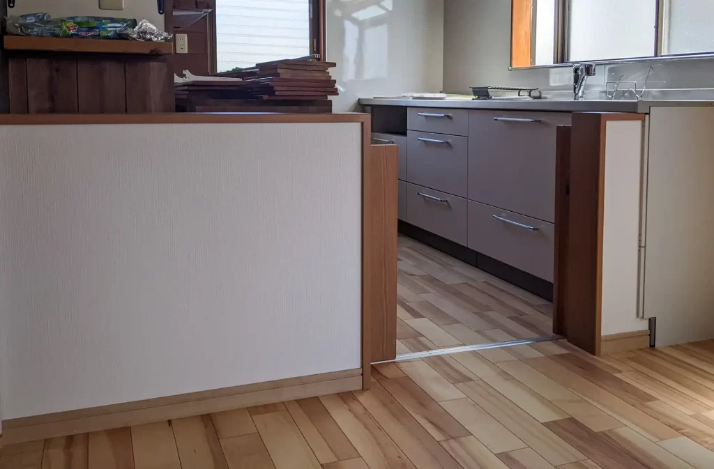 キッチン手前に壁を設置。壁は圧迫感が無いように腰高にして、ゲートも併せて低いものにしました。児童がキッチンに来るのを防ぎます。