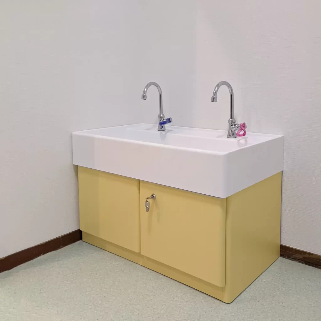 児童用の手洗い。高さは500㎜程度と低い。使いやすいように水栓のレバーハンドルは大きく、赤と青に色分けして少しでも手洗いが楽しくなるように工夫。